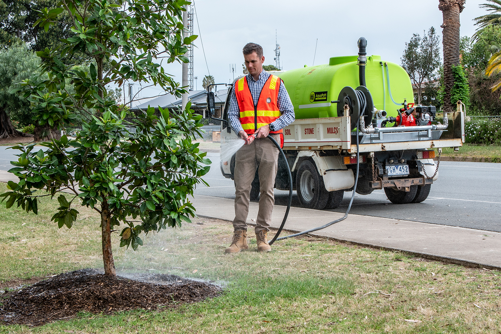 Man using water tank to water the plants