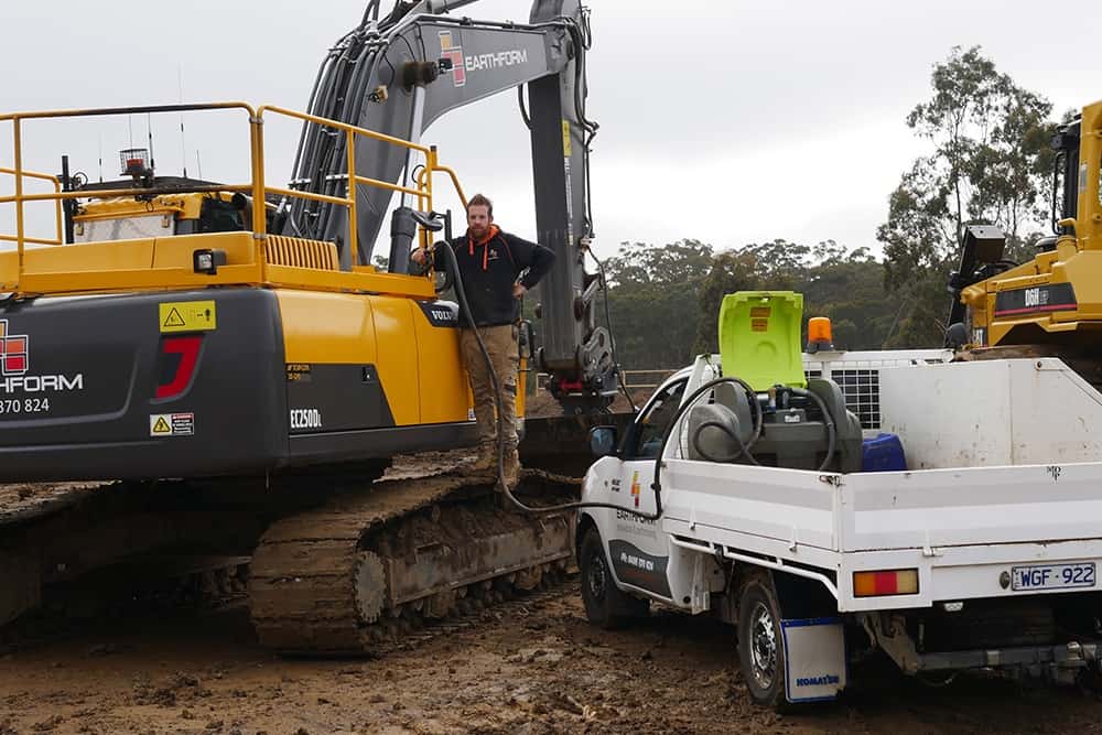Portable Diesel Fuel Tank Pod over the pickup truck refueling a heavy machinery vehicle